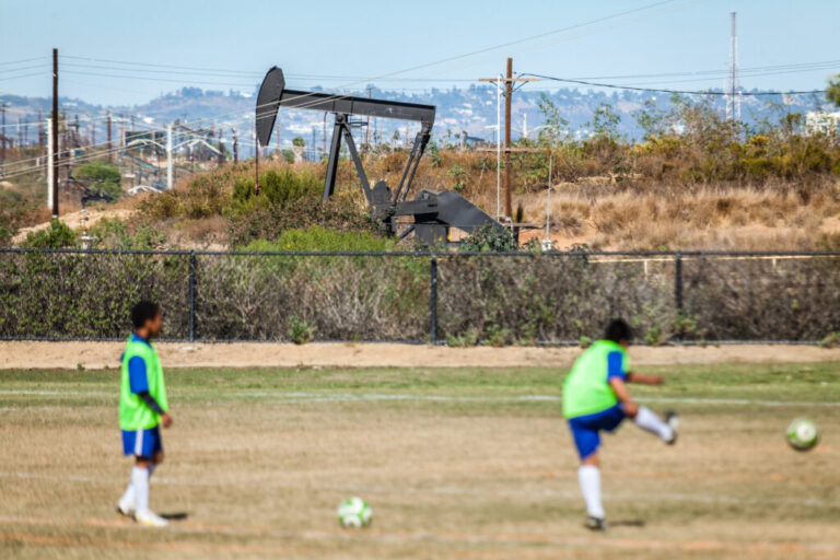 Children play soccer next to active oil wells in Los Angeles County’s Inglewood Oil Field, the largest urban oil field in the nation. Credit: Gary Kavanagh