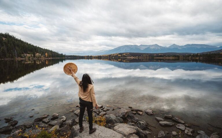 A warrior woman standing in front of a lake.