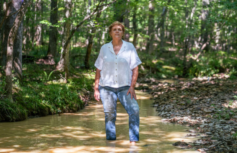 Andrea Childers stands in the creek on her property, which sits next to the Moriah Energy Center site in southeastern Person County.