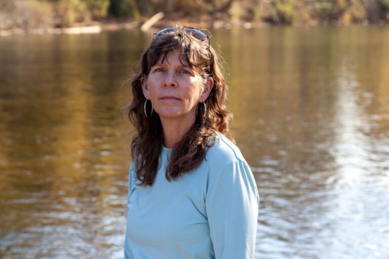 Shelley Robbins, the senior decarbonization manager for the Southern Alliance for Clean Energy, stands next to the Dan River in Rockingham County. Credit: Lisa Sorg/Inside Climate News