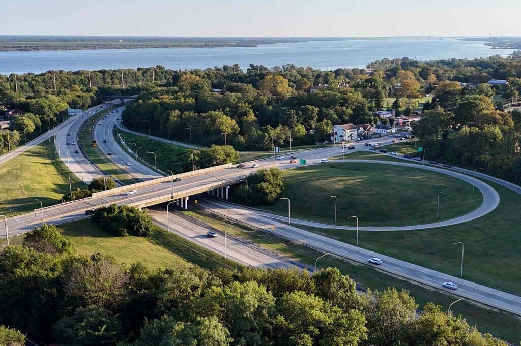 Aerial view of a highway interchange surrounded by trees and a river in the background possibly in Wilmington Delaware