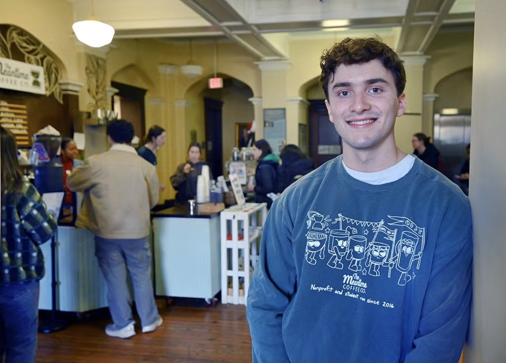 Kyle Daniels stands in front of the Meantime Coffee kiosk inside the Campus Y.