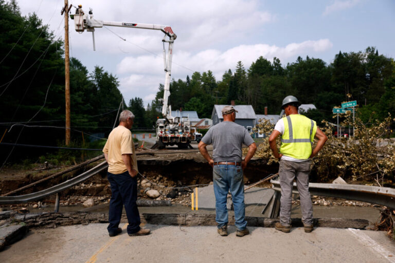 Workers survey the damage after flash floods collapsed a bridge in St. Johnsbury, Vt. Credit: Danielle Parhizkaran/The Boston Globe via Getty Images