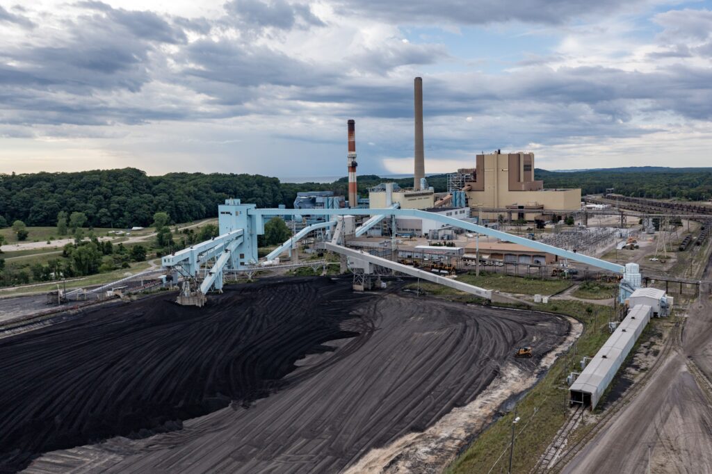A swath of coal is visible in front of the J.H. Campbell coal power plant in an aerial photo.